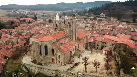 drone-shot-around-saint-bonnet-le-chateau-collegiate-church-in-the-Monts-du-Forez-near-Saint-Etienne,-Loire-departement,-France