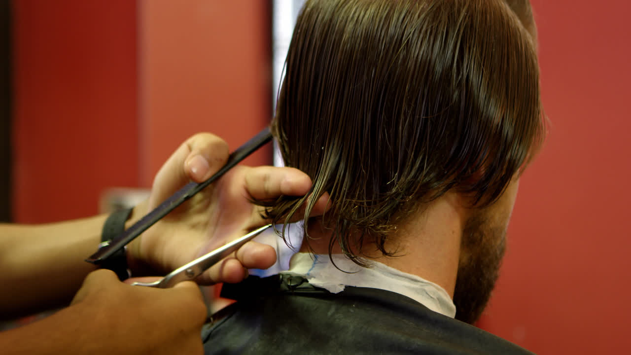 Mann lässt sich die Haare mit der Schere trimmen 4k