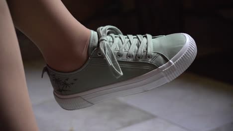 close-up of a light green sneaker with palm tree design lifted slightly off the ground