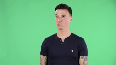 retrato de un joven guapo está mirando derecho y enfocado pensando en algo. pantalla verde
