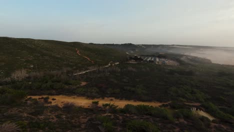 Die-Luftdünen-Zeigen-Den-Praia-Do-Guincho-Mit-Etwas-Nebel-Und-Einer-Mystischen-Atmosphäre-Im-Hintergrund