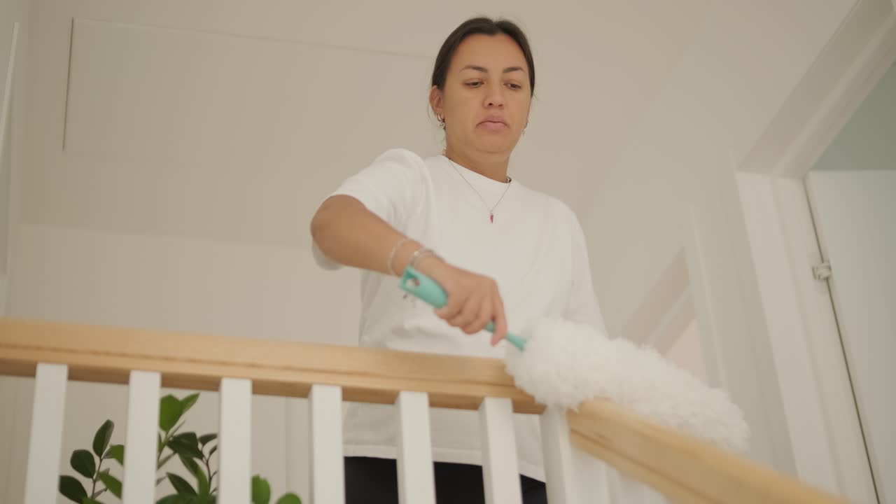 아름다운 임신한 여성이 집을 정리하고 집안일을 하고 있는 장면. 이 장면은 가정생활, 모성애, 그리고 임신 기간 동안의 일상과 준비의 균형을 담고 있다.