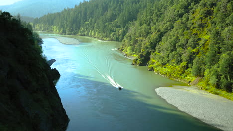 small boat going fast on the rogue river in oregon, near gold beach