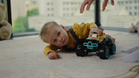 baby playing on carpet next to older brother. elder boy looking after younger