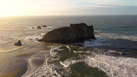 static aerial shot of oregon sea stack at golden hour