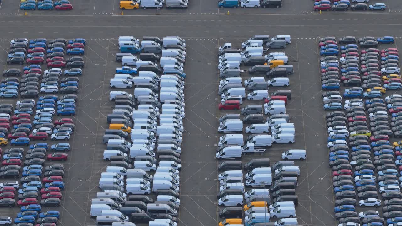 Luftfoto af farverige nye biler parkeret i havn til forhandlerdistribution