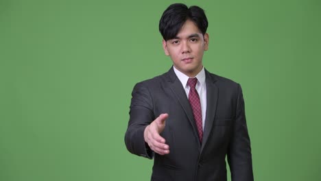 젊은 잘생긴 아시아 사업가 손잡이