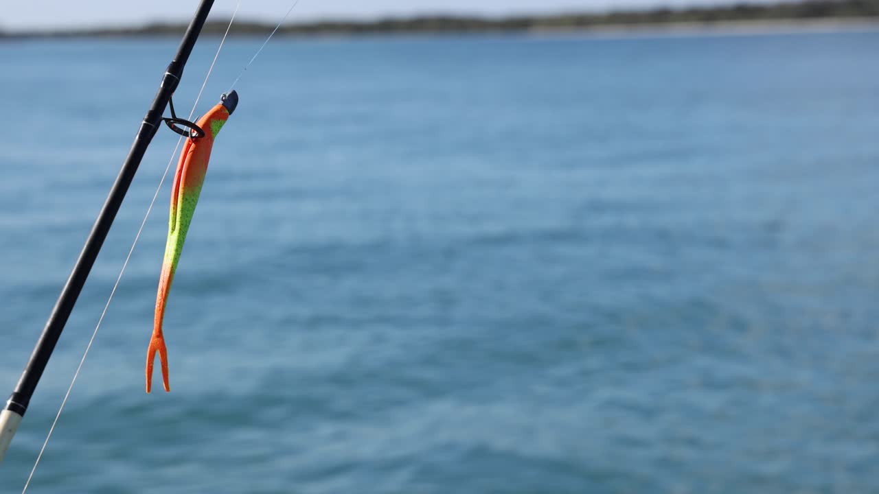 Canna da pesca con esca sopra acque calme dell'oceano