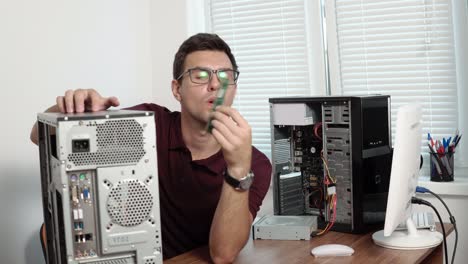 concentrated computer service worker in glasses fixing a broken computer in the office and upgrading computer hardware. support team. computer maintenance. shot in 4k