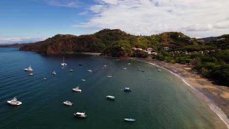 drone flying over a tropical coastal landscape bay where many ships are docked