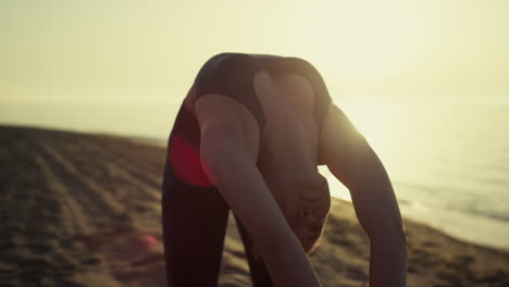 yoga woman bending back to ground close up. girl stretching body on nature.