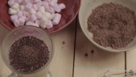 sprinkling chocolate toppings on hot chocolate drink