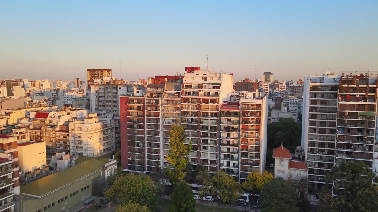 High-rise residential apartment buildings with balconies at golden hour near Parque Rivadavia in Buenos Aires, Argentina. Dolly in aerial