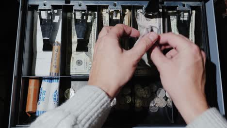 video pov: el cajero pone el dinero en la caja registradora y toma el cambio. venta al por menor por dólares estadounidenses en efectivo