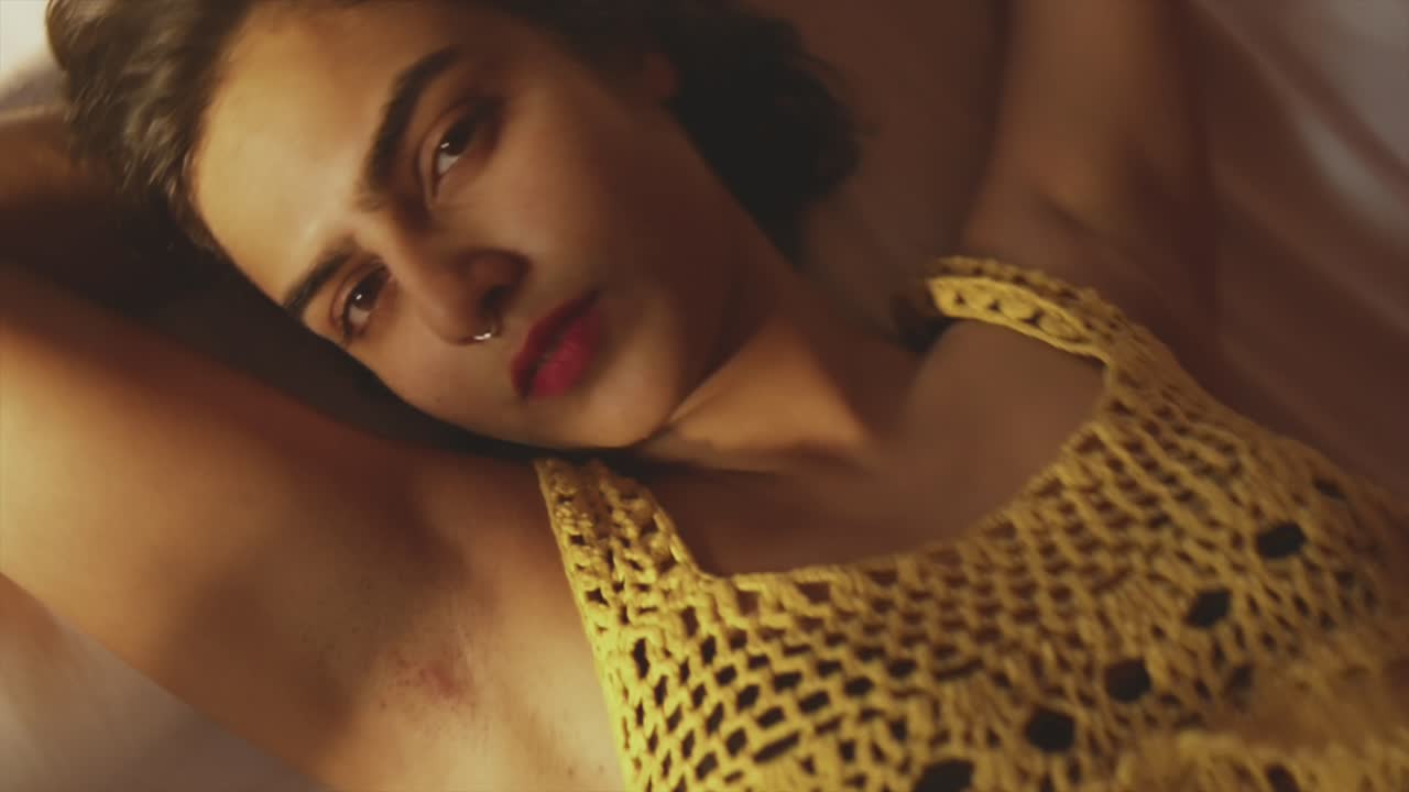 un primer plano en espiral hacia la cara de una atractiva modelo asiática acostada en una cama