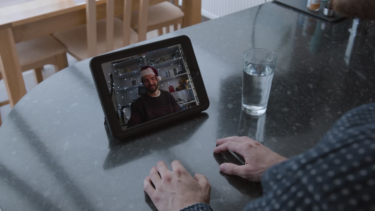 2 Males speaking on videocall, while wearing a Christmas hat