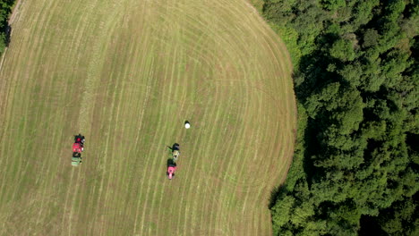 Aerial-Birds-Eye-View-Of-Pair-Of-Tractors-On-Green-Field-In-Chmielno