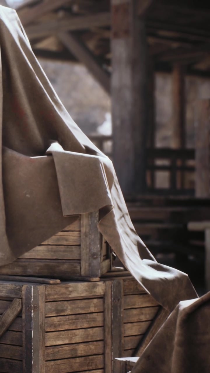 Casse di legno coperte da un telo in un contesto rustico all'aperto durante il giorno.