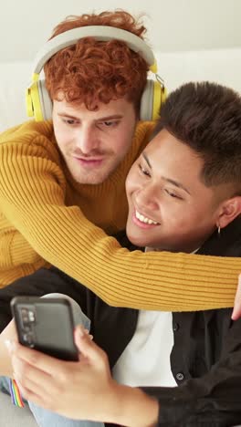 a happy gay couple embracing while looking at a smartphone