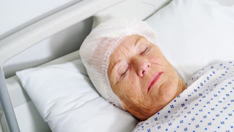 une femme âgée dort sur le lit.