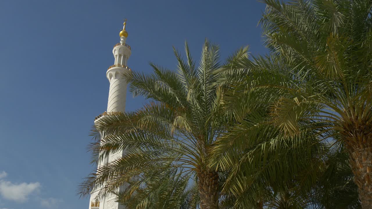 siang hari langit biru Abu Dhabi, menara Masjid Agung Sheikh Zayed yang terkenal, pemandangan pohon palem 4K Uni Emirat Arab