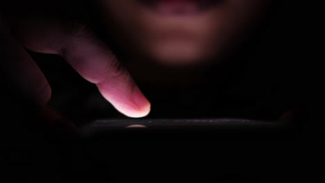 persona que utiliza un teléfono inteligente por la noche