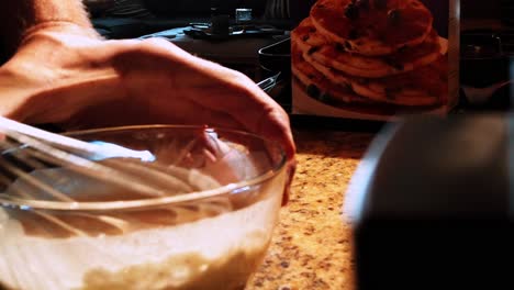 reveal shot, male whisking pancake batter mix, in a bowl, for breakfast, los angeles, california, usa