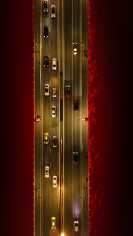 vertical top-down drone shot of twin river bridges with cars above yangtze river at night in chongqing, yuzhong district, china