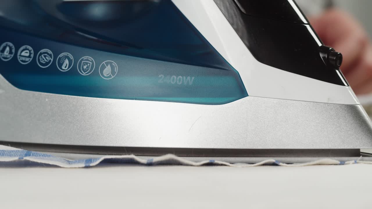 Close-up of a Person Ironing a Checkered Cloth