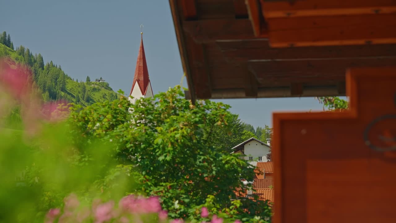 Attractive blonde with white robe admires view of Austria, Berwang from hotel balcony