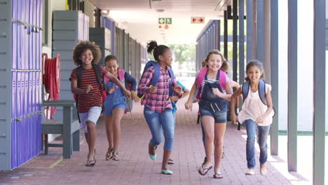 kids running to camera in school hallway, front view