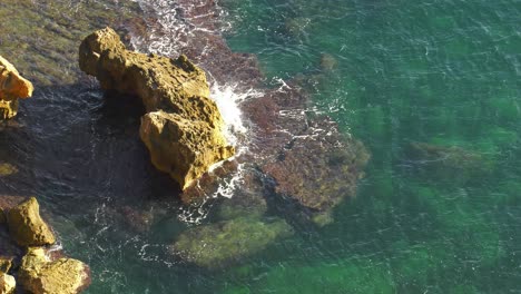 Las-Olas-Del-Océano-Tropical-Rompen-En-Pequeños-Islotes-Rocosos,-En-Cámara-Lenta-Desde-Arriba