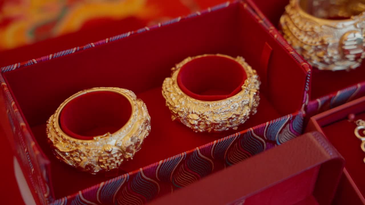 Ornate gold Chinese wedding bangles in red presentation boxes