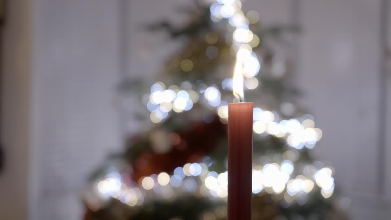 vela roja frente a un árbol de navidad