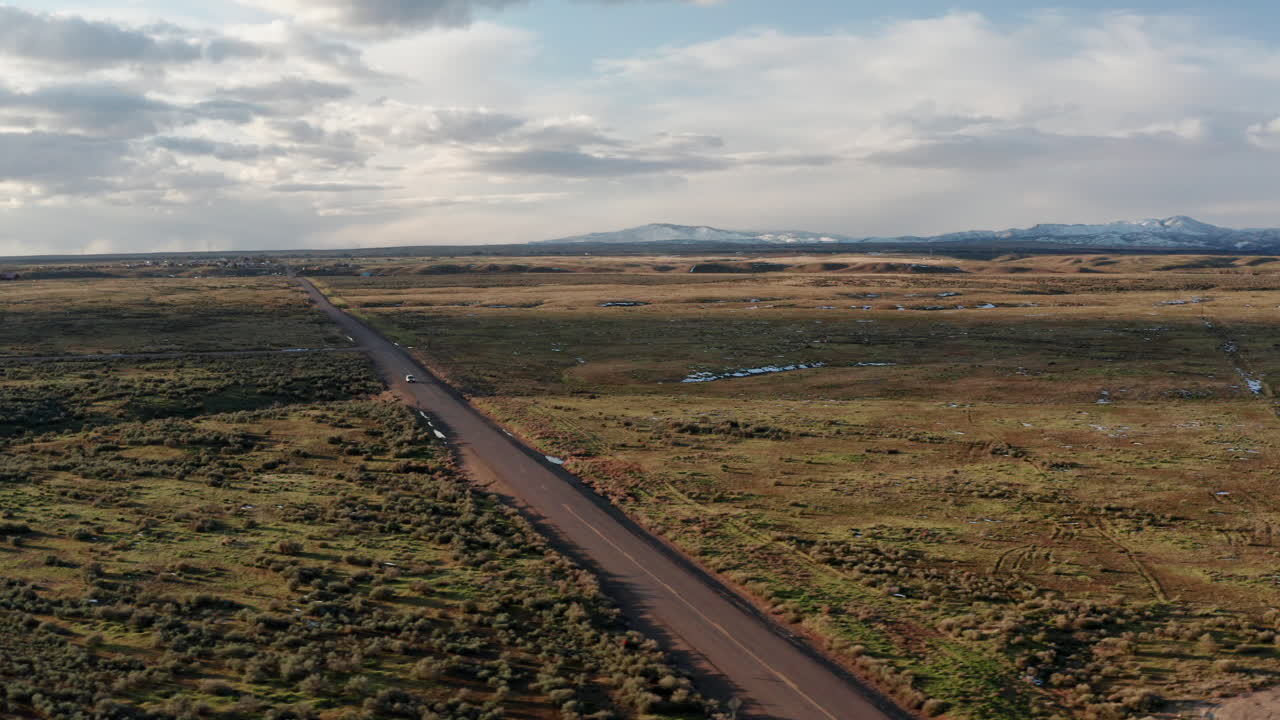 antena panorámica del vehículo que conduce a través de la vasta llanura de idaho con montañas