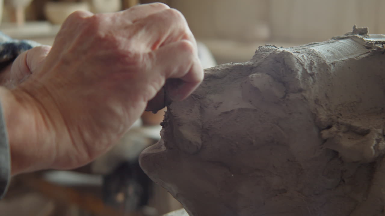 작업실 에서 점토 머리 를 만드는 노인 조각가