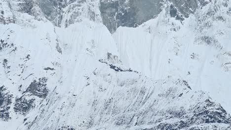 cara de montaña cubierta de nieve empinada cerca en las montañas del himalaya en nepal, paisaje de montaña cubierto de nieve blanca, cara de montaña escarpada en invierno