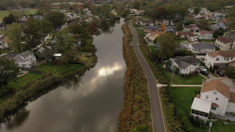 An-aerial-drone-shot-over-a-reflective-pond-on-a-cloudy-afternoon