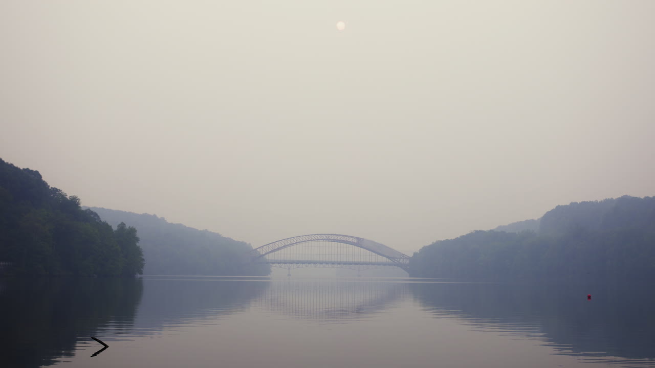 The sun barely shining through the smokey sky above the AMVETS Memorial Bridge in New York