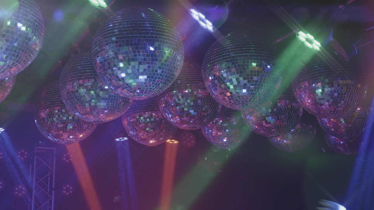 Mehrere Discokugeln, die bunte Bühnenlichter reflektieren