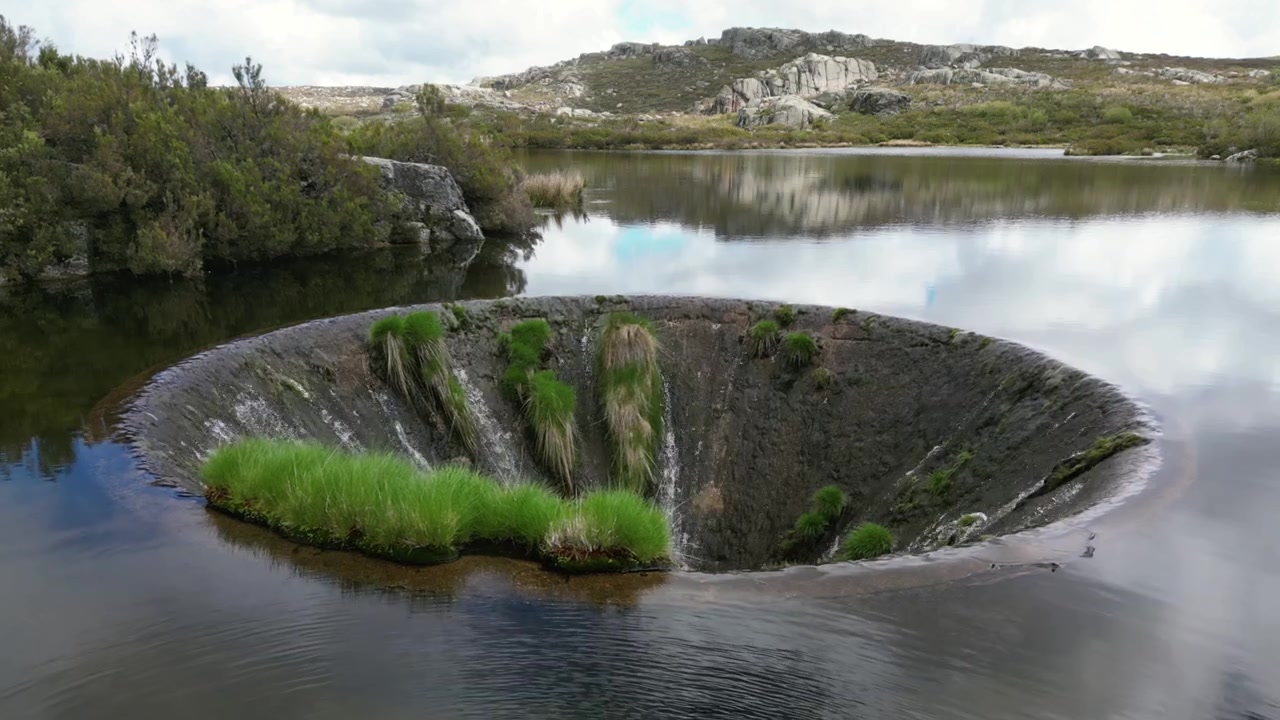 Portekiz, Covão dos Conchos'un havadan drone görüntüleri: Serra da Estrela manzarasıyla çevrili, eşsiz dairesel bir savaklı dağ gölü. Seyahat ve doğa projeleri için idealdir.