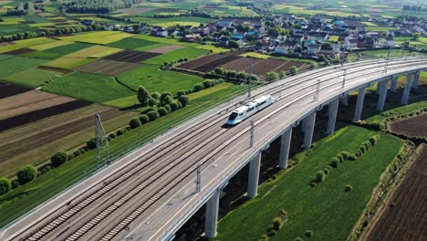 high-speed train crossing a countryside overpass