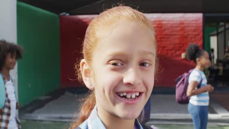 Portrait-of-happy-caucasian-schoolgirl-with-happy-diverse-group-of-children-in-background