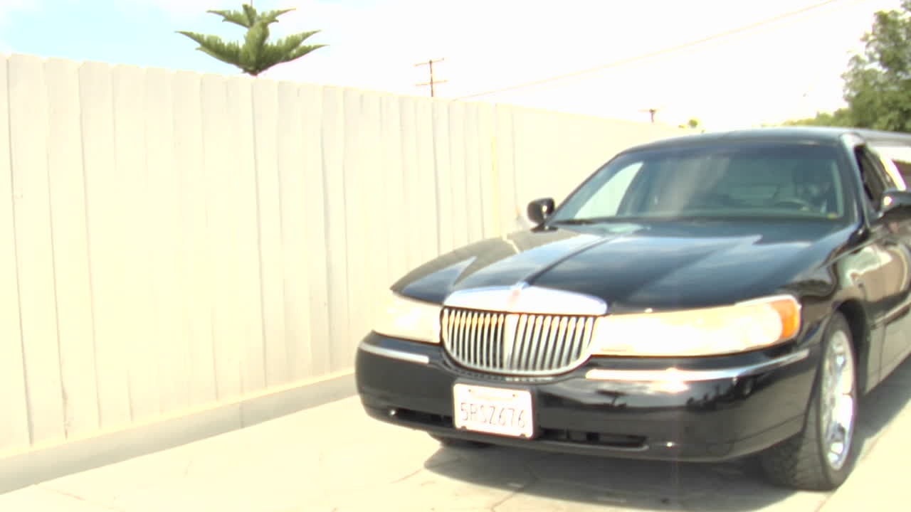 방독면을 쓴 남자가 리무진을 타고 앞으로 나아간다