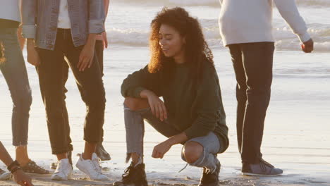 Freunde-Spielen-Nullen-Und-Kreuze-Im-Sand-Am-Winterstrand