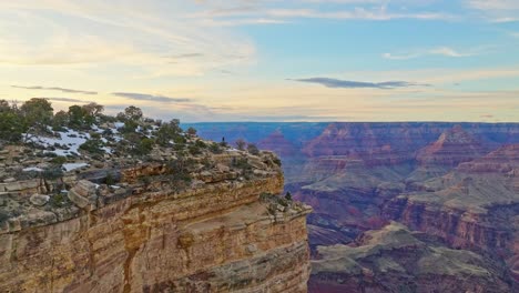 Tourist-Standing-On-The-The-Edge-Of-The-Cliff-In-Grand-Canyon-National-Park,-Arizona,-USA---aerial-drone-shot