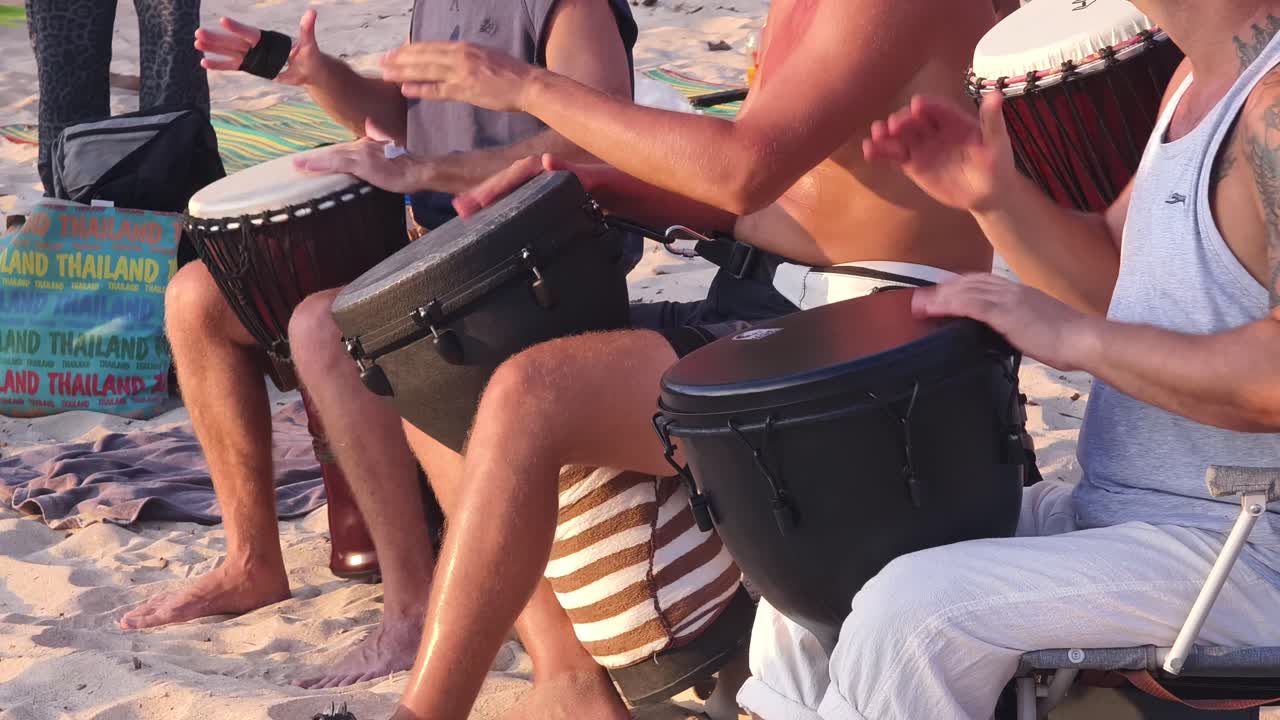 gente tocando tambores en la playa