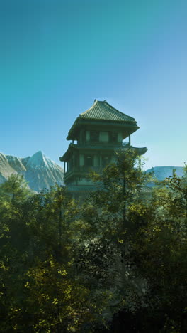 a tower in a forest with mountains in the background