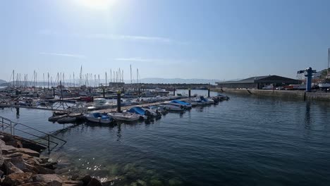 Kleines-Ausflugsboot-Segelt-Zwischen-Den-Anderen-Booten,-Die-Den-Yachthafen-Füllen,-Um-An-Einem-Sonnigen-Sommermorgen-Vor-Der-Küste-Zum-Fischen-Hinauszufahren.-Beschreibende-Blockierte-Aufnahme