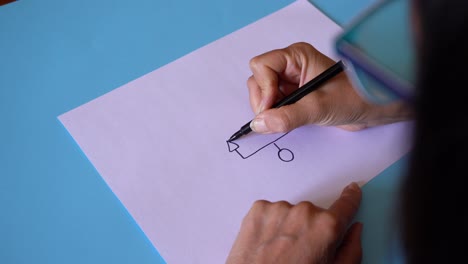 female hand drawing basic genogram symbols on plain white paper